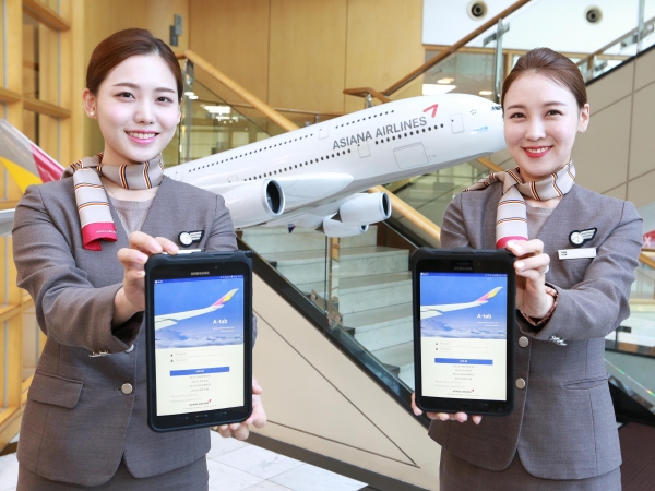 아시아나항공 캐빈승무원들이 새롭게 지급받은 태블릿 PC를 들어보이고 있다.