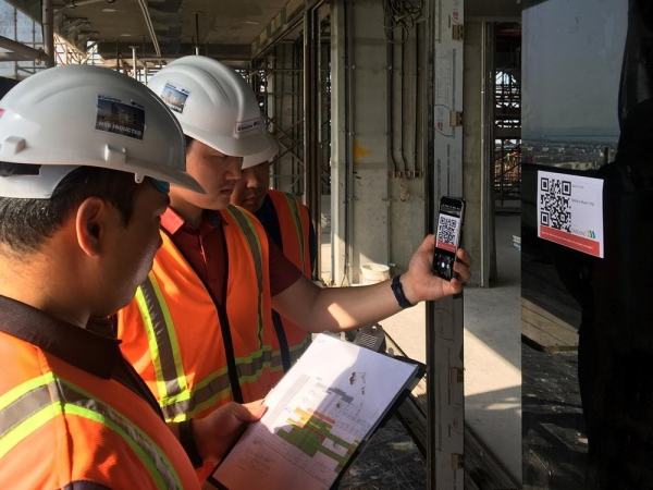 두바이 로얄 아틀란티스 리조트 & 레지던스 현장 직원들이 건물 벽면에 부착된 QR코드를 통해 실시간 공사 현황을 확인하고 있다.