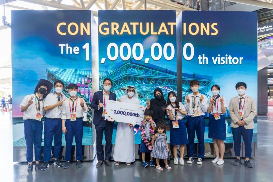 두바이 엑스포 한국관 100만번째 관람객이 축하 화환과 선물을 받고 기념사진을 촬영하고 있다.