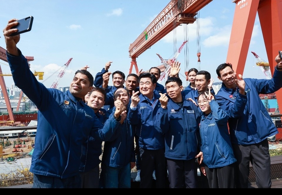 HD현대 권오갑 회장이 외국인 근로자들과 기념 촬영을 하고 있는 모습.